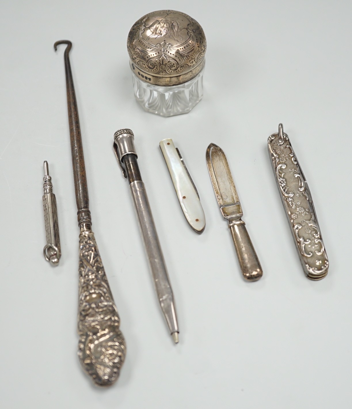 Sundry small silver including an Edwardian silver mounted pocket knife, mounted toilet jar, mounted button hook and a book mark (a.f.), together with a French white metal mounted Edacoto pencil (a.f.) and two other items